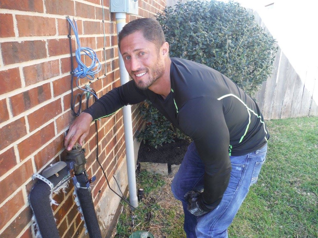 Elite Sprinkler technician on an irrigation repair at a Katy home