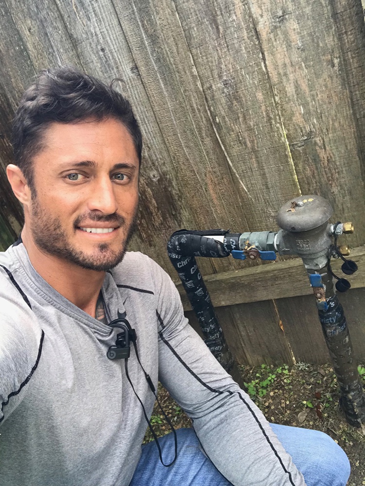 Elite Sprinkler technician beside a freshly completed repair