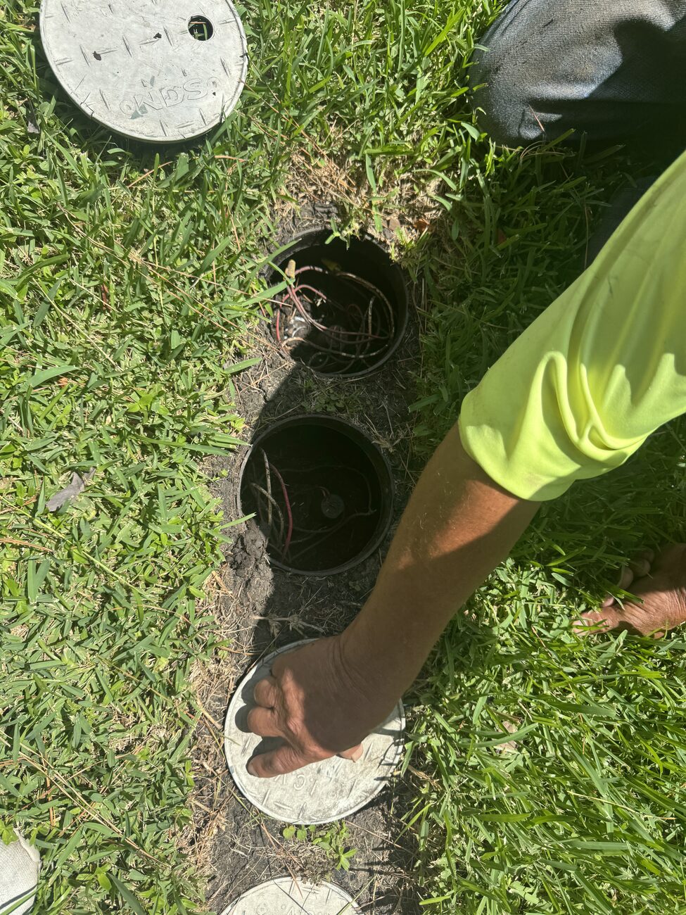 Elite Sprinkler technician evaluating an irrigation system at a Katy home